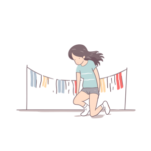 A young woman is squatting near a clothesline with colorful laundry.